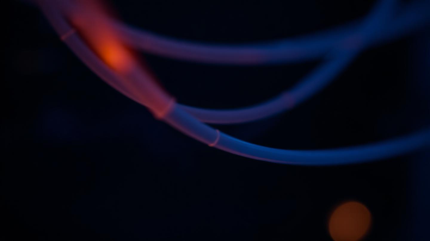 Fibres optiques illuminées symbolisant les infrastructures numériques et les flux de données régulés.